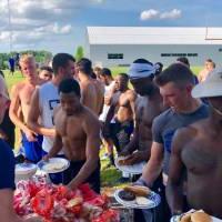 Football team getting food from full table